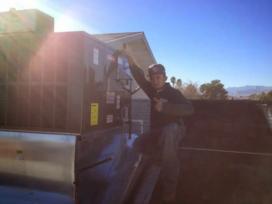HVAC technician performing Heat Pump Repair on a rooftop unit in Frenchtown